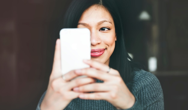 Stile di vita di refrigerazione della bella donna facendo uso del concetto dello smartphone