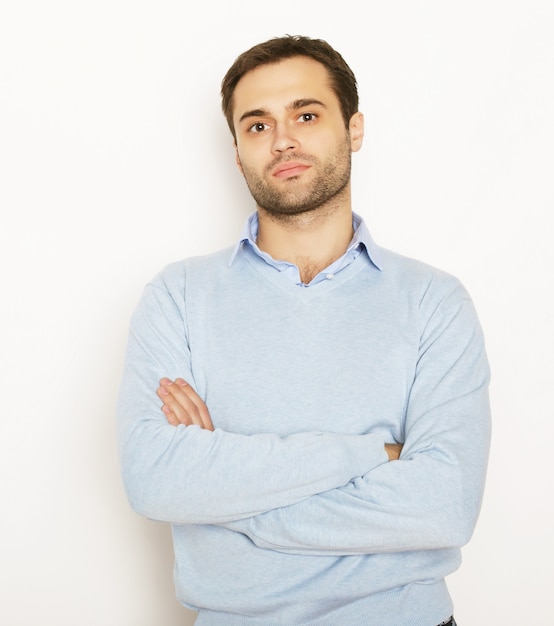 Stile di vita e concetto della gente: giovane felice in camicia blu. Su sfondo bianco.