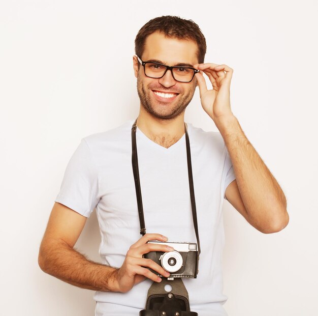 Stile di vita e concetto di persone: giovane con una fotocamera retrò su sfondo bianco