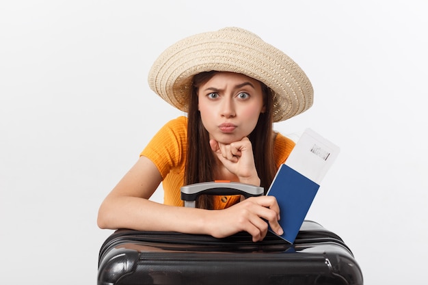 Stile di vita e concetto di viaggio: La giovane bella donna caucasica è seduta sulla valigia e sta aspettando il suo volo. Isolato sopra bianco