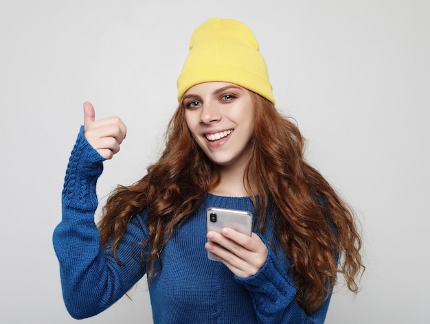 Stile di vita emotivo e concetto di persone Giovane donna riccia con smartphone