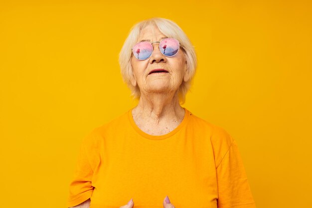 Stile di vita felice della donna anziana sorridente nelle emozioni del primo piano delle magliette gialle