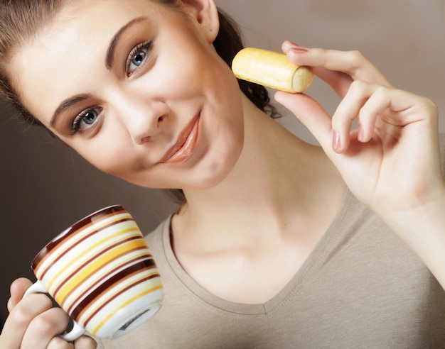 Stile di vita persone e concetto di cibo giovane donna con caffè e biscotti