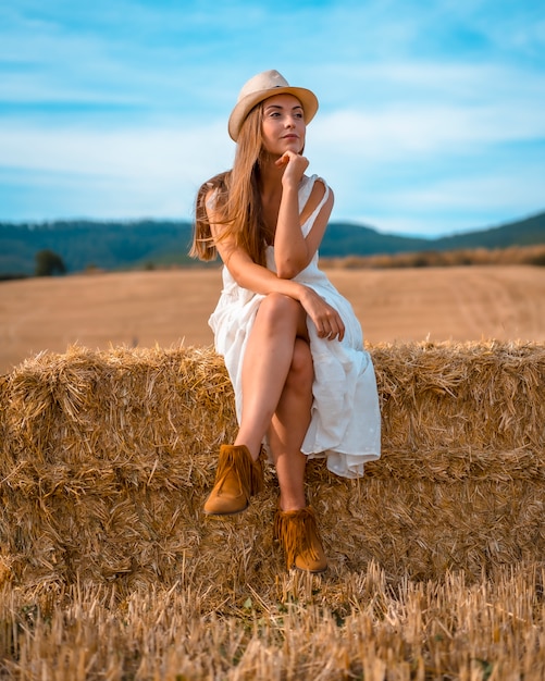 Stile di vita rurale, una giovane ragazza di campagna bionda in un campo di grano secco vicino a Pamplona