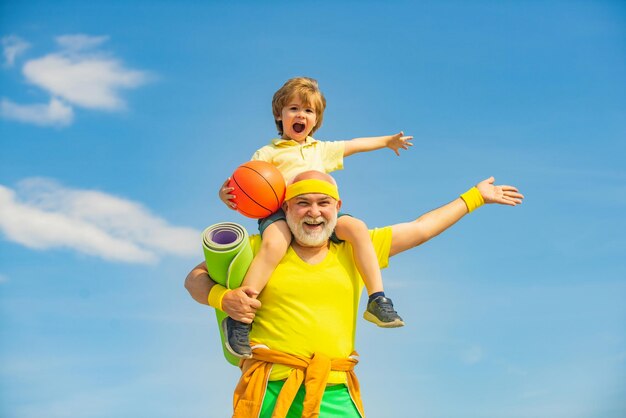 Stile di vita sano e attivo a qualsiasi età concetto fitness senior uomo e figlio che si allenano su backgrou blu