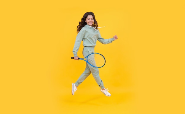 Stile di vita sano e attivo sport successo infanzia felice bambino salto con racchetta bambino energico con racchetta da tennis ragazza adolescente correre all'allenamento dedicato al fitness tennis o giocatore di badminton