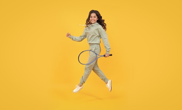 Stile di vita sano e attivo sport successo infanzia felice bambino salto con racchetta bambino energico con racchetta da tennis ragazza adolescente correre all'allenamento dedicato al fitness tennis o giocatore di badminton