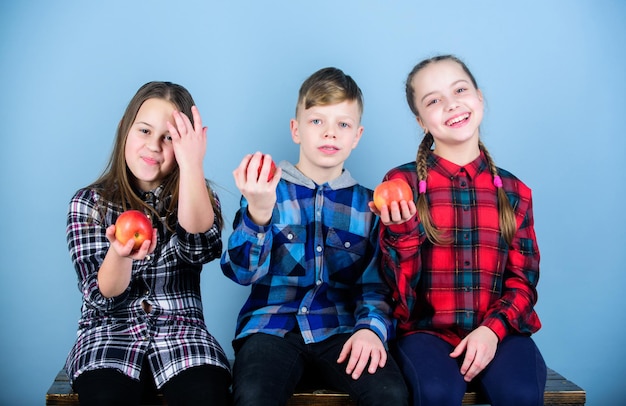 Stile di vita sano Gli adolescenti del gruppo tengono le mele Ragazzi e ragazze con abiti simili a scacchi mangiano mele Adolescenti con uno spuntino sano Dieta sana e nutrizione vitaminica Mangia frutta e sii sano