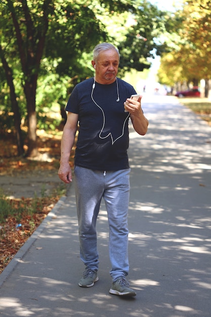 Stile di vita sano nel concetto di vecchiaia. Uomo maggiore che cammina nel parco