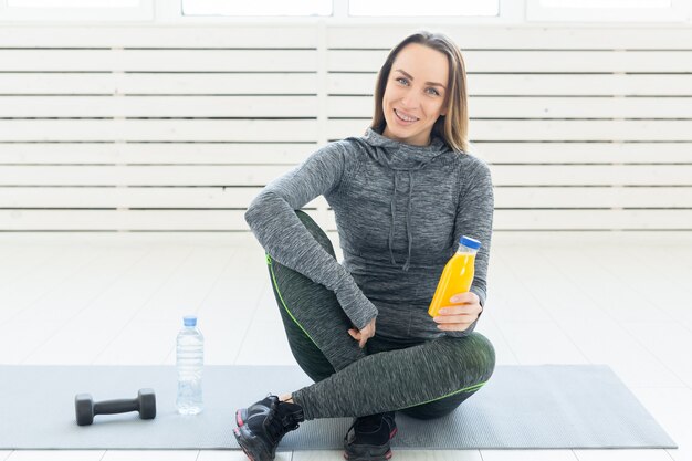 Stile di vita sano, sport e concetto di persone - bella ragazza con un frullato di fitness