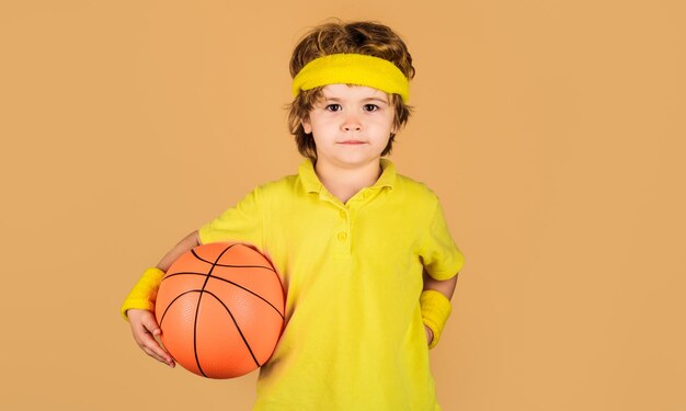 Stile di vita sportivo attivo bambino carino in abbigliamento sportivo con palla da basket piccoli sport da basket