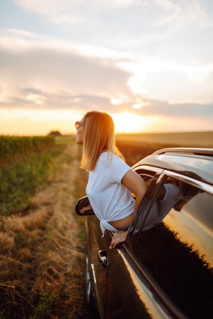 Stile di vita Turista donna si riposa e si appoggia fuori dal finestrino dell'auto si gode il viaggio Viaggio concetto vacanza