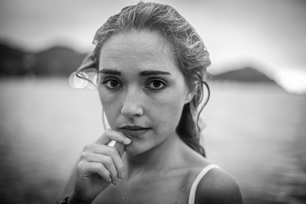 Stile di vita, una giovane bionda con un bikini bianco all'interno con i capelli bagnati, foto in bianco e nero