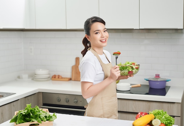 Stile di vita vegano. Alimentazione sana. Femmina con insalatiera di verdure fresche. Felice giovane casalinga.