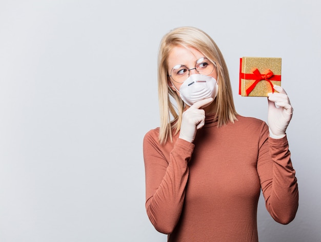 Stile donna bionda in maschera con scatola regalo