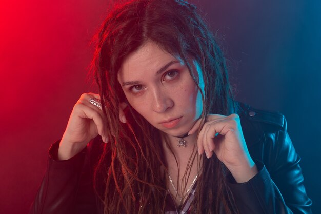 Stile, gioventù, concetto di persone - la giovane donna con i dreadlock sembra rocker.