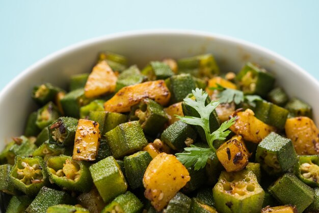 Stile indiano Masala Sabji O Sabzi di Bhindi fritto O Okra noto anche come Ladyfinger, servito in una ciotola su sfondo lunatico. messa a fuoco selettiva