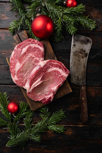 Stile natalizio Perfetto bistecca di manzo cruda, su vecchio sfondo di tavolo in legno scuro, vista dall'alto piatto