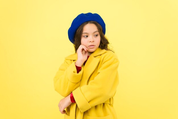 Stile personale e sartoria su misura Sentirsi comodi e a proprio agio con un cappotto adeguato Tutti hanno bisogno di un cappotto quest'inverno Ragazza alla moda modello carino indossa un cappotto di lana giallo Bambino pensieroso in abiti caldi