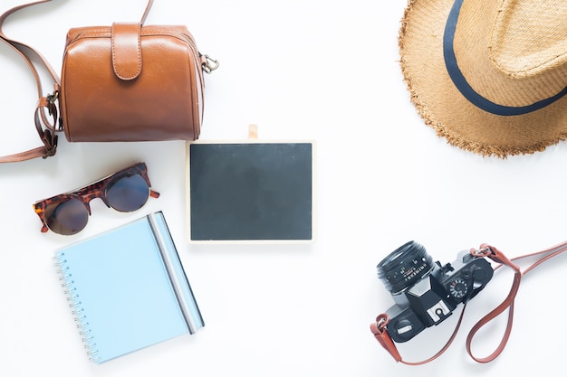 Stile piano di accessori estivi, articoli di viaggio su sfondo bianco con bordo bianco per il testo