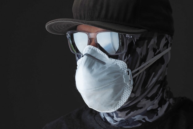 Stili di vita. Avvicinamento. Ritratto di un maschio su maschera protettiva e occhiali da sole. Le persone proteggono da Covid-19 o 2019 nCoV.
