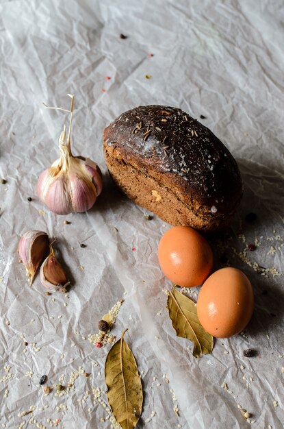 Still life di pane, uova, aglio e spezie.