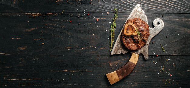 Stinco di vitello tagliato a croce fresco alla griglia per fare Osso Buco su mannaia di carne Vista dall'alto in formato banner lungo