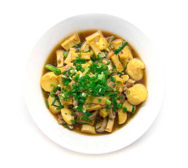 Stire fritto tofu con carne di maiale e shitake mashroom in cima con cipollotto e salsa di sugo Thai vista superiore in stile isolato