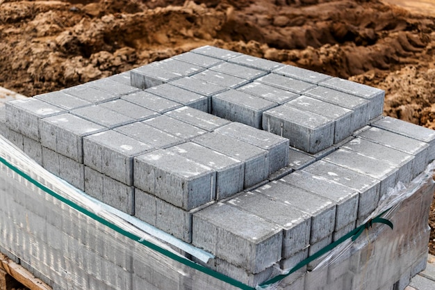 Stoccaggio di lastre per pavimentazione su pallet in cantiere. Lastre per pavimentazione in calcestruzzo pronte per l'installazione. Magazzino prodotti finiti.