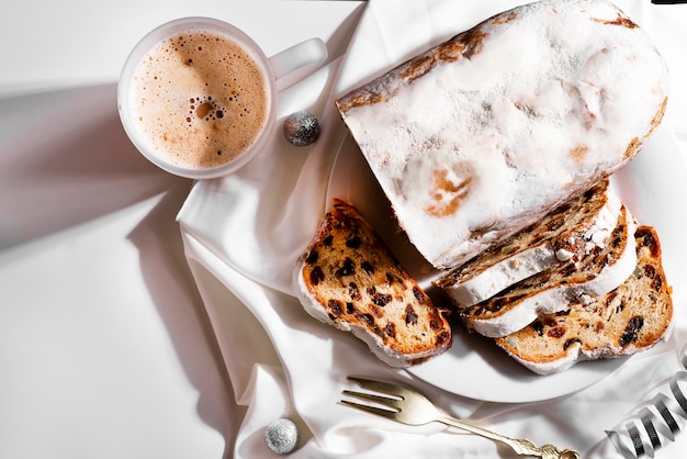 Stollen di Natale e spezie su sfondo bianco