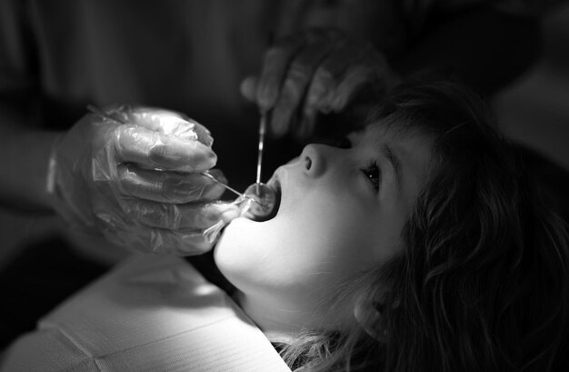 Stomatologia e cura dei denti per bambini concetto dentista che controlla i denti di un bambino paziente in odontoiatria