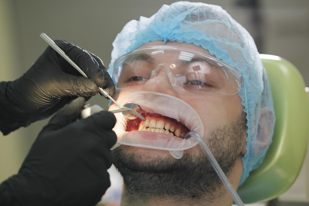 Stomatologia sanitaria - paziente maschio alla poltrona del dentista, primo piano