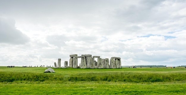 Stonehenge con un turista non riconosciuto vicino a Salisbury, in Inghilterra, sotto il cielo nuvoloso