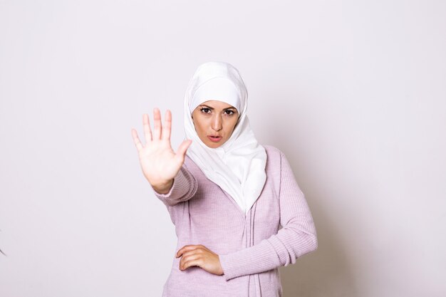 Stop Abuse. Donna afroamericana spaventata in hijab che rifiuta qualcosa con il gesto di mano aperto della palma