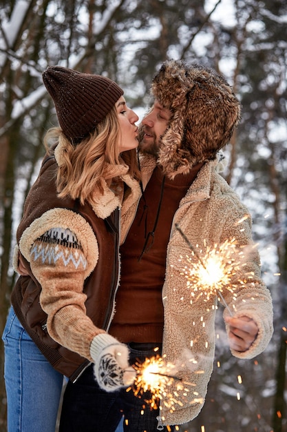 Storia d'amore di coppia nella foresta di neve Baciare e tenere le stelle filanti Coppia in inverno Natura Coppia che celebra la data di San Valentino