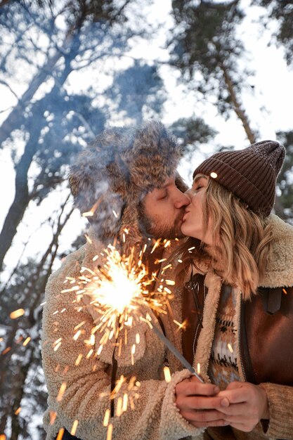 Storia d'amore di coppia nella foresta di neve Baciare e tenere le stelle filanti Coppia in inverno Natura Coppia che celebra la data di San Valentino