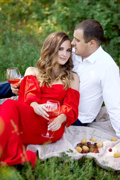 Storia d'amore di una coppia amorevole di uomini e donne in primavera nella natura nella foresta. Abbracci di coppia, picnic al parco in