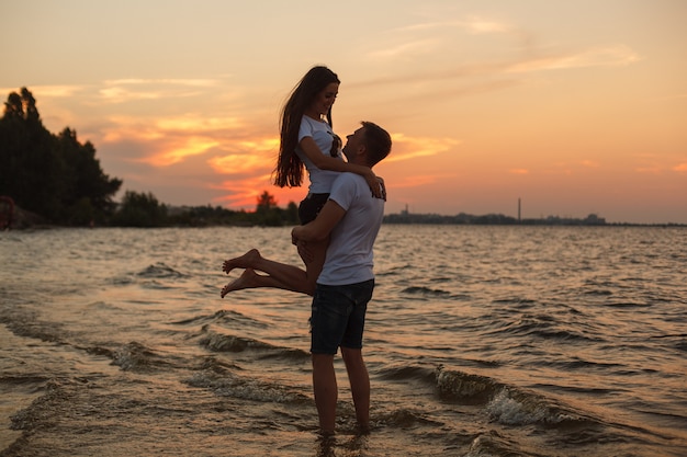 storia d'amore sulla spiaggia Giovane bella coppia amorosa che abbraccia sulla spiaggia al tramonto.