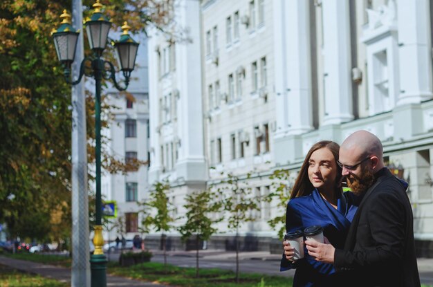 Storia d'amore urbana. giovane uomo barbuto in un abito blu. Donna attraente in abito. Coppia che cammina. Data