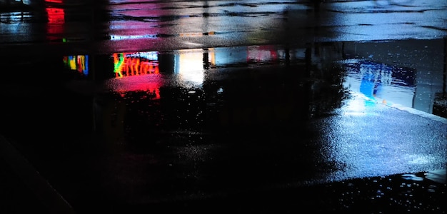 Storia urbana astratta, luci e ombre, strade dopo la pioggia con riflessi sull'asfalto bagnato., immagine orizzontale con sfondo sfocato, spazio libero per il testo, sfocatura sfocata