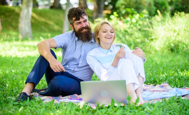 Storie di successo familiare e innovazione duraturi. Coppia innamorata o lavoro di famiglia freelance. Commercio online moderno. La famiglia trascorre il tempo libero all'aperto con laptop da lavoro. Come bilanciare freelance e vita familiare.