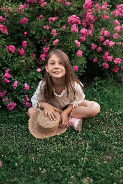 Storie estive di una bambina Maglietta bianca Cappello di paglia Rose rosa