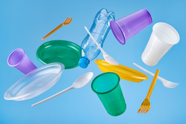 Stoviglie di plastica usa e getta volanti multicolori Il concetto di ecologia e riciclaggio della plastica w