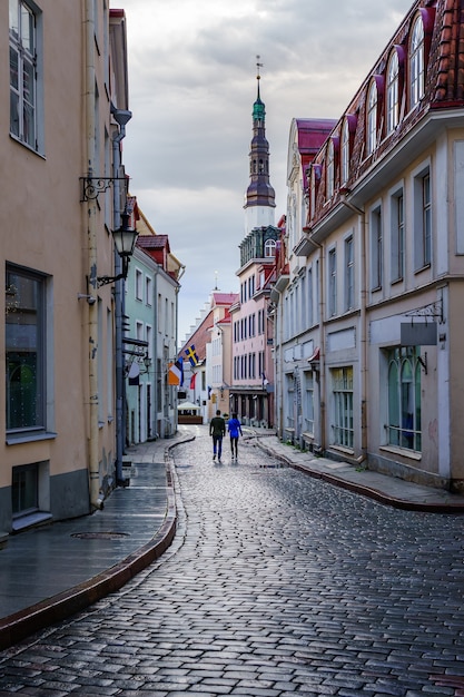 Strada acciottolata medievale con coppia che passeggia per la strada. Tallinn Estonia.