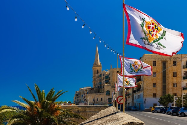 Strada addobbata a festa con le bandiere di tutti i Gran Maestri del Sovrano Militare Ordine di Malta nella città vecchia di La Valletta, Malta