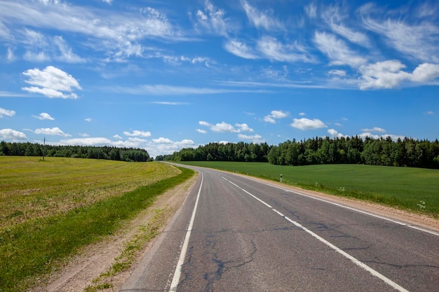 Strada asfaltata con cielo azzurro e nuvole