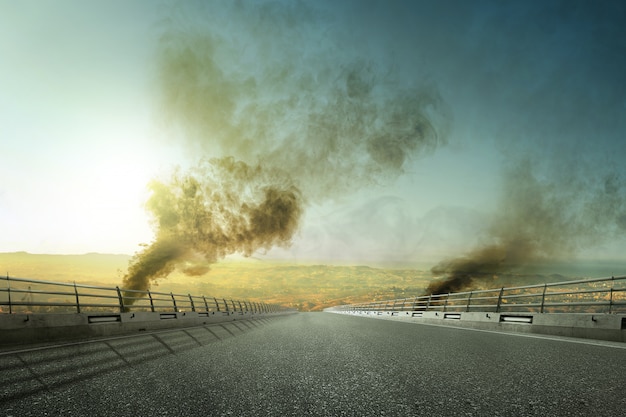 Strada asfaltata con fumo scuro e inquinamento atmosferico dagli incendi boschivi