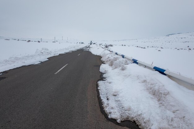 Strada asfaltata con paesaggio innevato