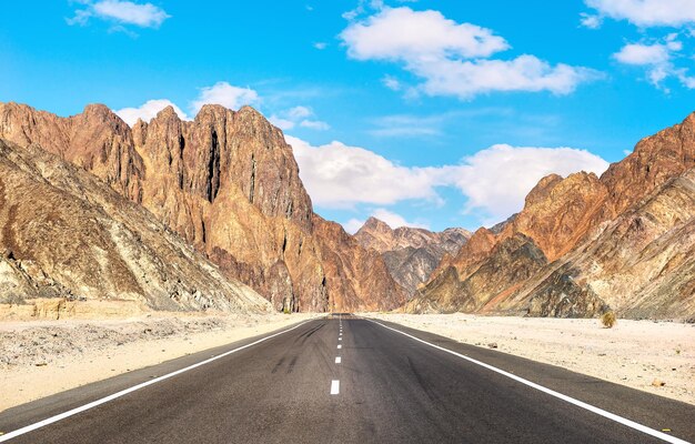 Strada asfaltata e alte montagne nel deserto egiziano