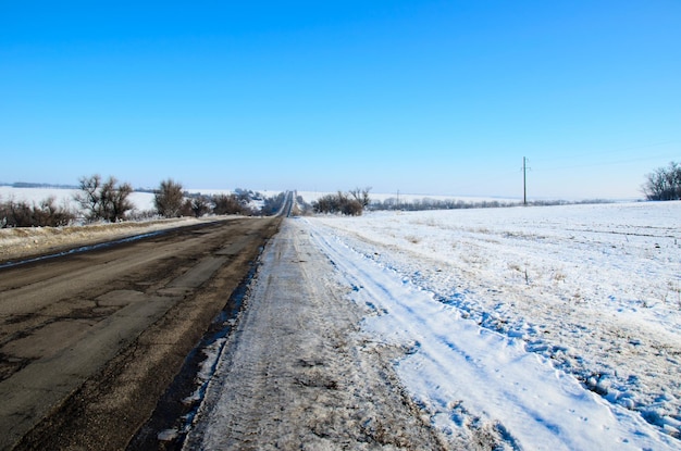 Strada asfaltata in una campagna in inverno